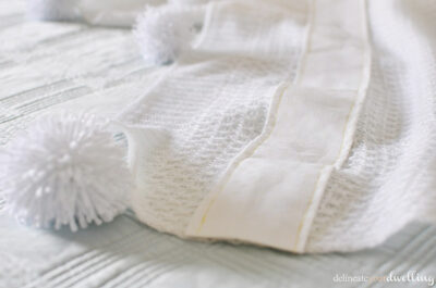 Learn to make a cozy Yarn Pom Pom Throw Blanket